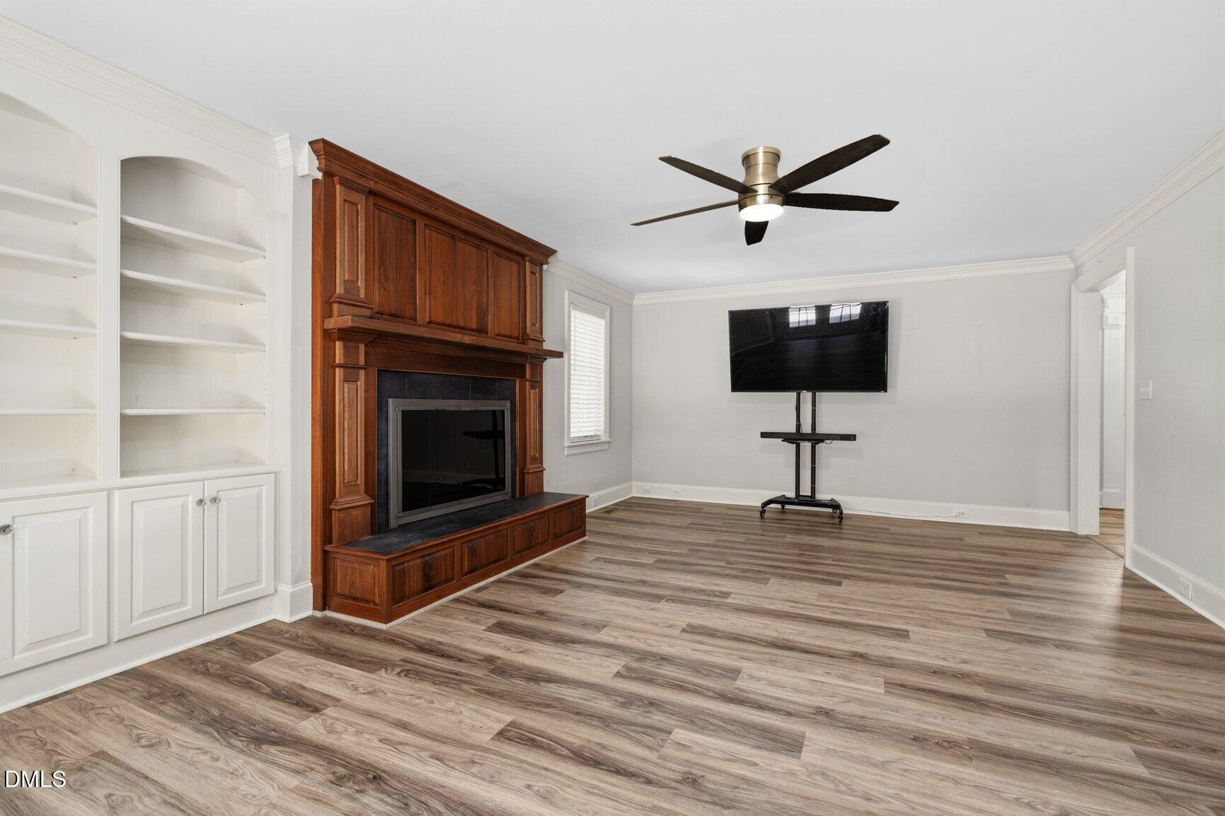 726 Thomas Road Rocky Mount, NC 27801 - Photo 8 of 55 a view of a livingroom with a fireplace a ceiling fan and wooden floor