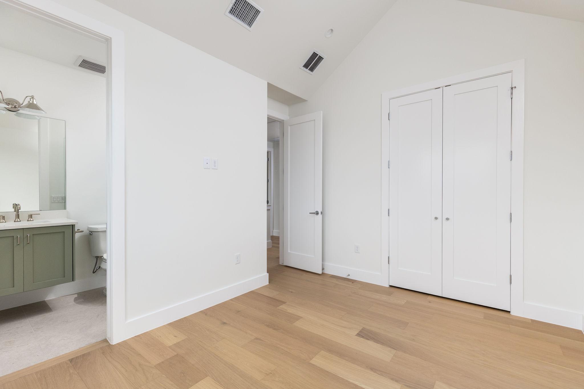 408 Linden Street, Unit B Austin, TX 78702 - Photo 21 of 40 Unfurnished bedroom featuring light wood-type flooring, ensuite bath, and a high ceiling