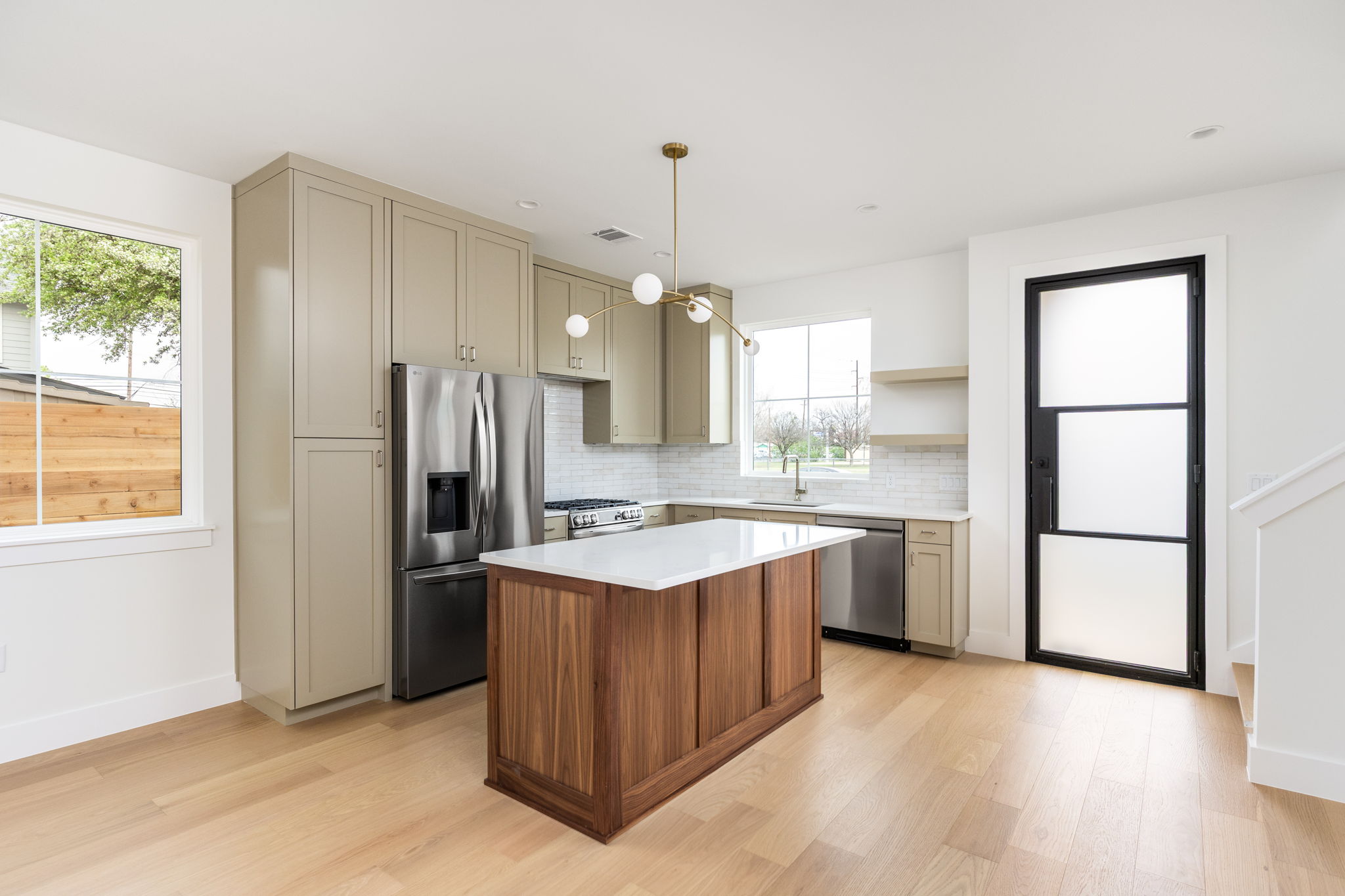 408 Linden Street, Unit B Austin, TX 78702 - Photo 7 of 40 Kitchen featuring stainless steel appliances, decorative backsplash, a center island, and light wood-type flooring
