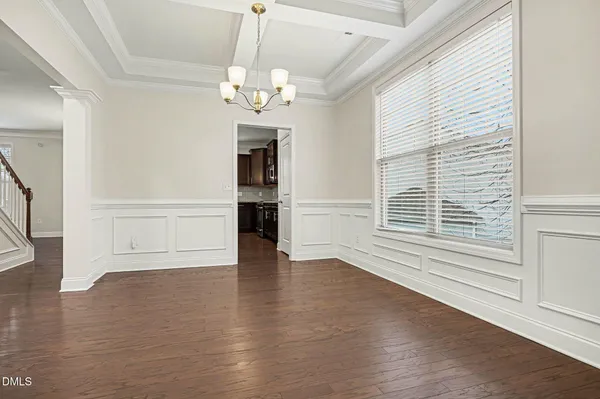 an empty room with wooden floor fireplace and fan