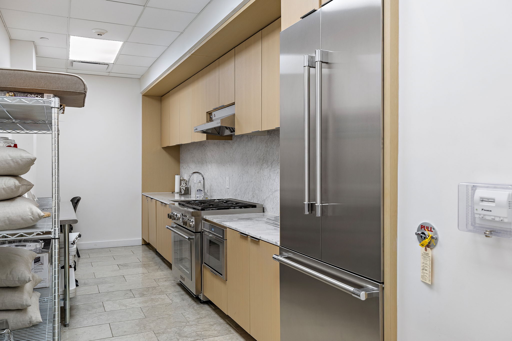 44 East Avenue, Unit 1210 Austin, TX 78701 - Photo 32 of 40 Common Kitchen with premium appliances, modern cabinets, light wood finish cabinetry, light stone counters, and a drop ceiling