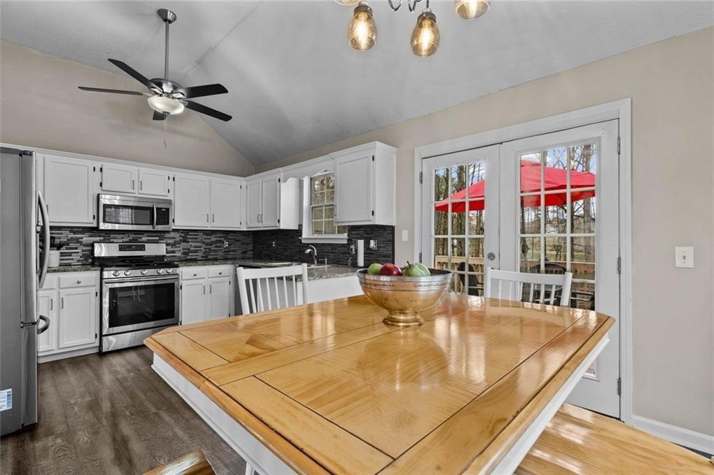 304 Ridge Hill Circle Canton, GA 30115 - Photo 12 of 42 a kitchen with kitchen island a stove a sink a refrigerator dining table and chairs with wooden floor