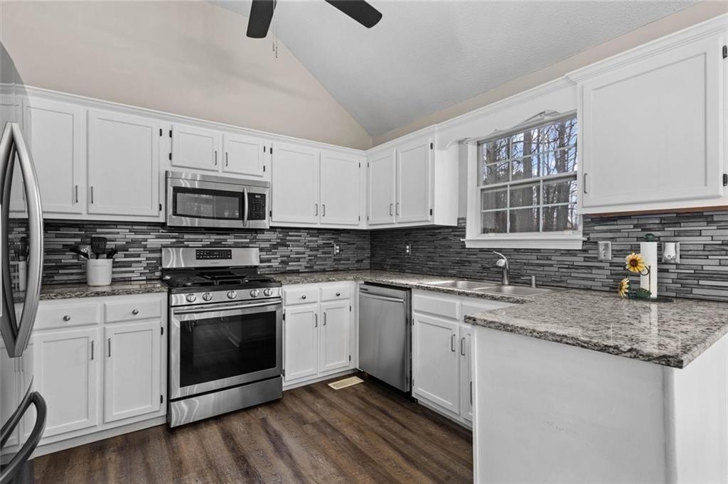 304 Ridge Hill Circle Canton, GA 30115 - Photo 13 of 42 a kitchen with granite countertop a sink stainless steel appliances and white cabinets