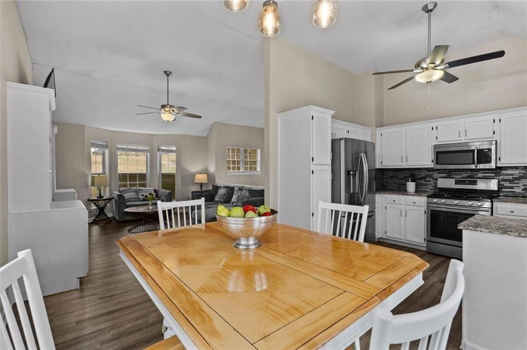 304 Ridge Hill Circle Canton, GA 30115 - Photo 15 of 42 a dining room with stainless steel appliances kitchen island granite countertop a dining table chairs and a refrigerator