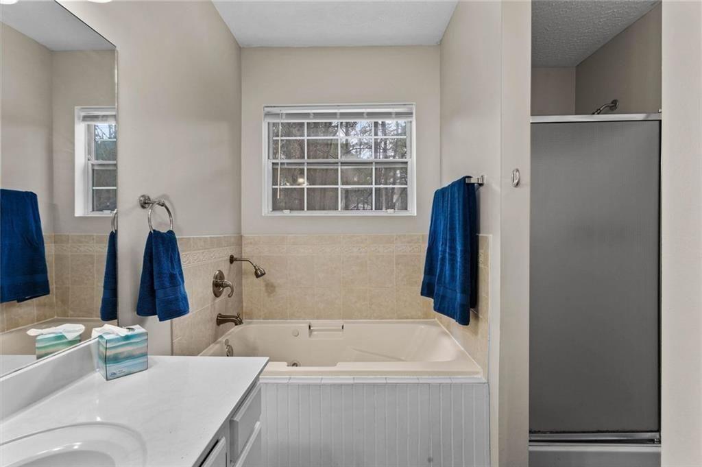 304 Ridge Hill Circle Canton, GA 30115 - Photo 19 of 42 a bathroom with a tub sink and a mirror
