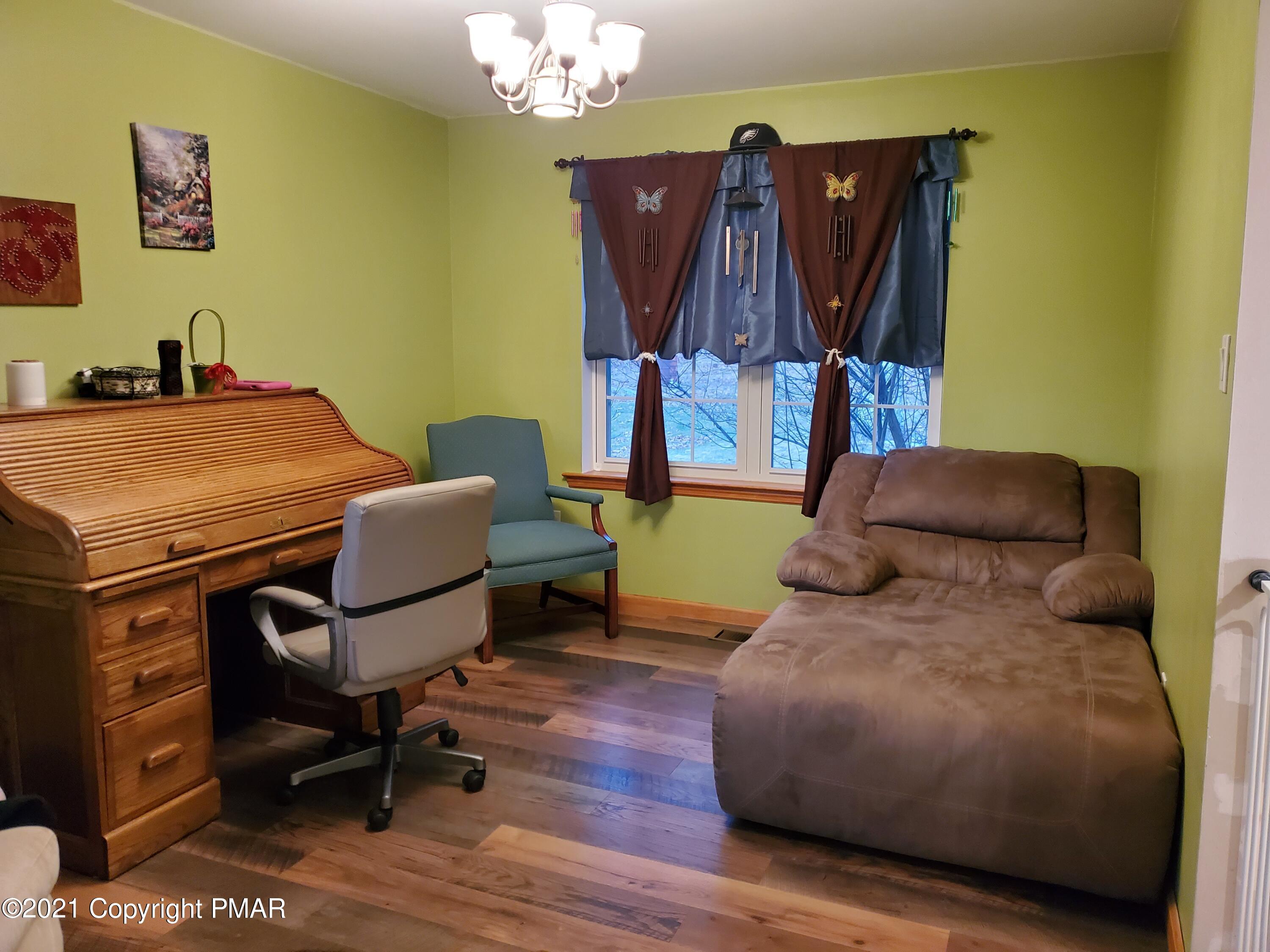 590 Henry's Crossing Road Cresco, PA 18326 - Photo 15 of 31 a living room with furniture a rug and a chandelier