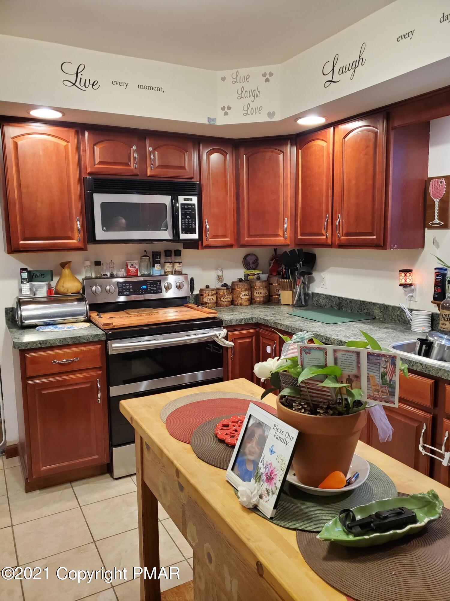 590 Henry's Crossing Road Cresco, PA 18326 - Photo 21 of 31 a kitchen with stainless steel appliances a stove a sink dishwasher and cabinets with wooden floor