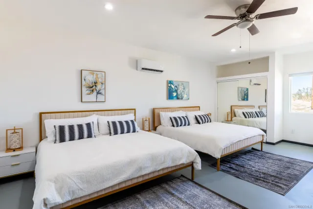 a spacious bedroom with a bed and a flat screen tv