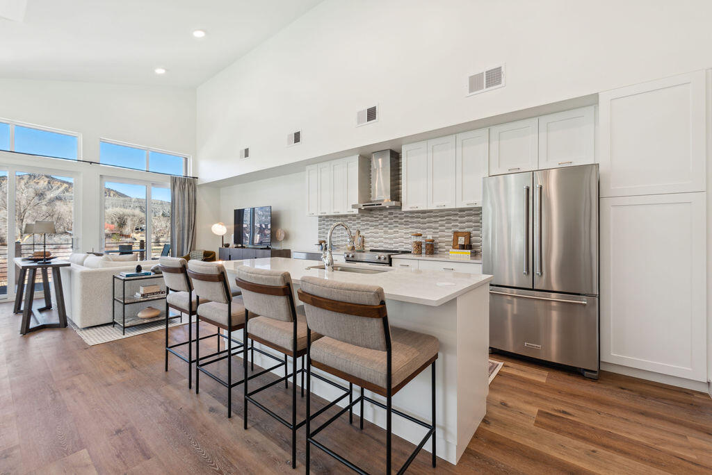 176 Alpine Lane, Unit 300 M2 301 Ridgway, CO 81432 - Photo 31 of 37 a kitchen with stainless steel appliances a refrigerator a stove a sink dishwasher and a dining table with wooden floor