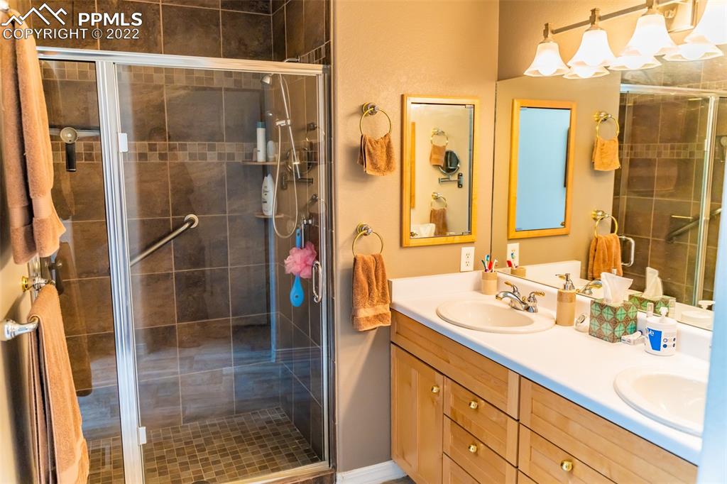 2755 Quail Ridge Point Colorado Springs, CO 80906 - Photo 24 of 35 a bathroom with a shower sink and mirror