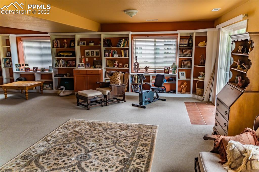 2755 Quail Ridge Point Colorado Springs, CO 80906 - Photo 28 of 35 a living room with furniture gym equipment and a large window