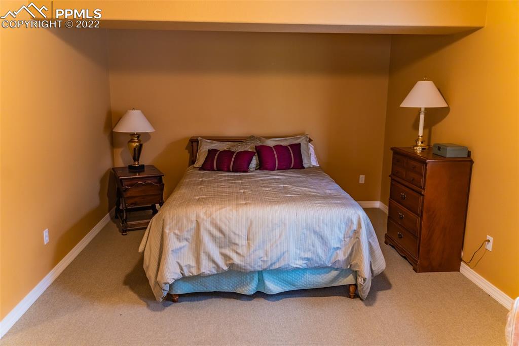 2755 Quail Ridge Point Colorado Springs, CO 80906 - Photo 30 of 35 a bedroom with a bed and a lamp