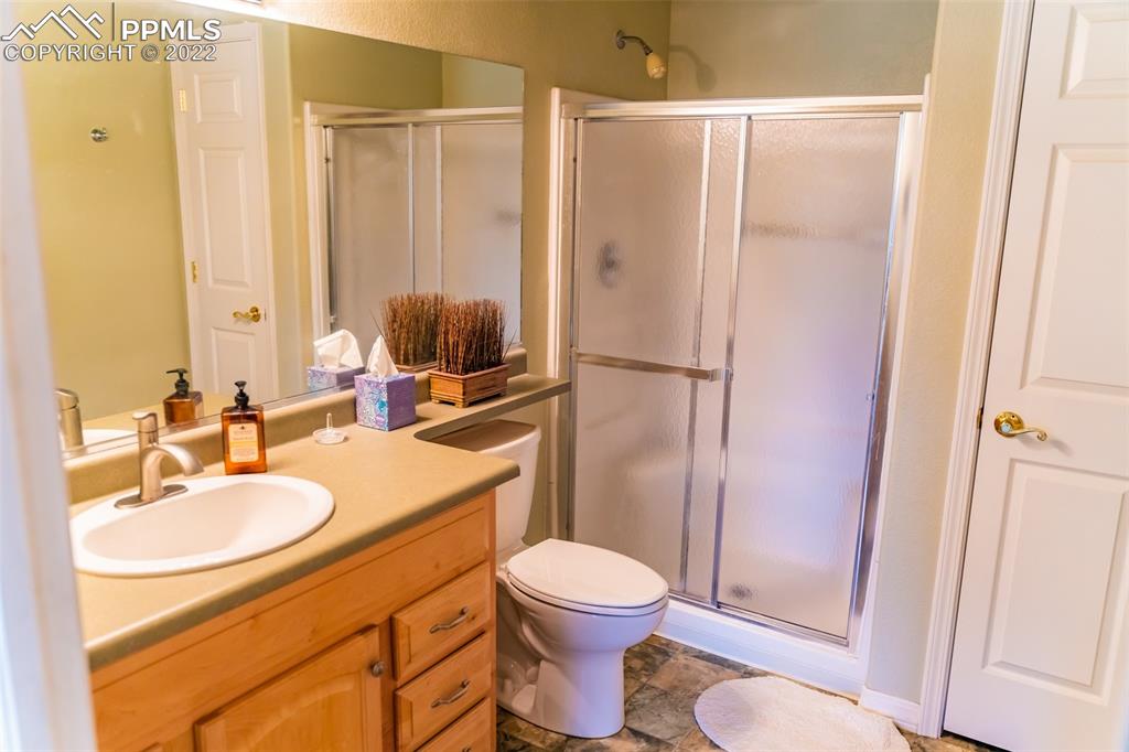 2755 Quail Ridge Point Colorado Springs, CO 80906 - Photo 31 of 35 a bathroom with a sink toilet a mirror and shower
