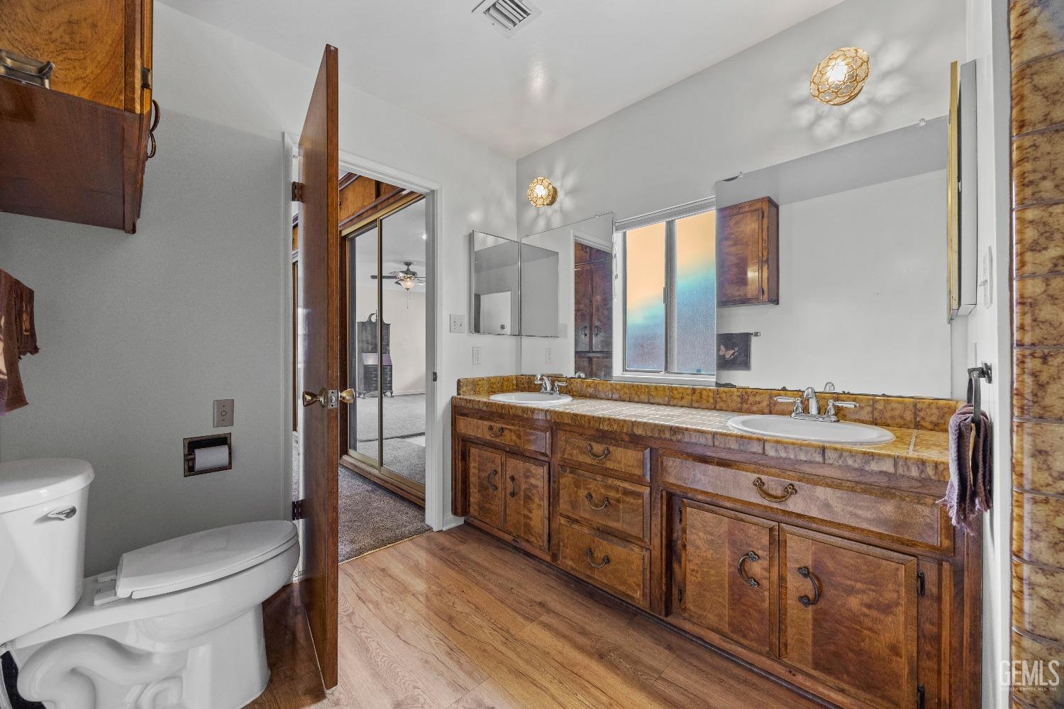 Undisclosed Address Bakersfield, CA 93308 - Photo 14 of 36 a spacious bathroom with a granite countertop sink a toilet a mirror and shower
