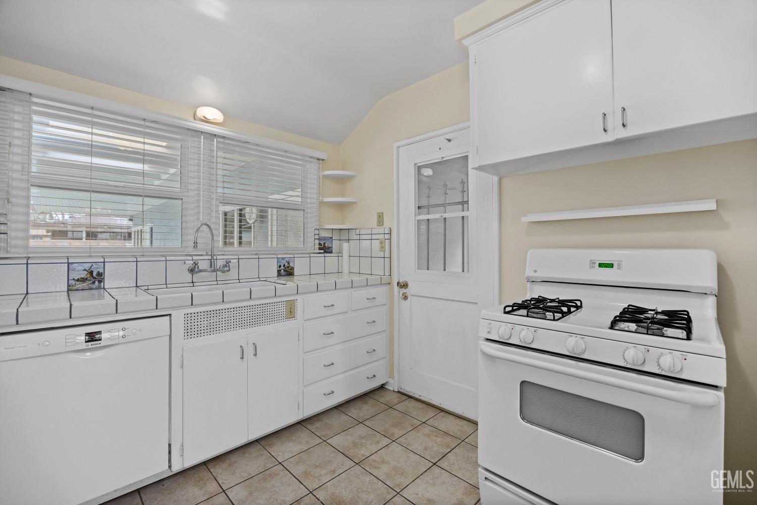 Undisclosed Address Bakersfield, CA 93308 - Photo 7 of 36 a kitchen with white cabinets and appliances