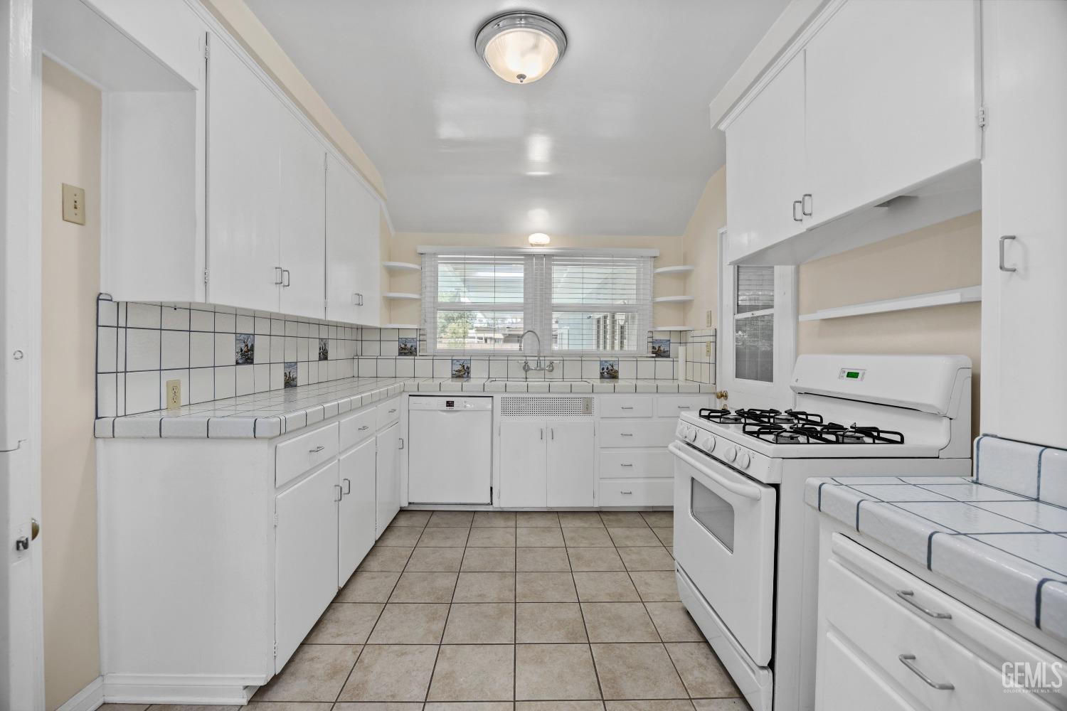 Undisclosed Address Bakersfield, CA 93308 - Photo 8 of 36 a kitchen with a stove sink and cabinets