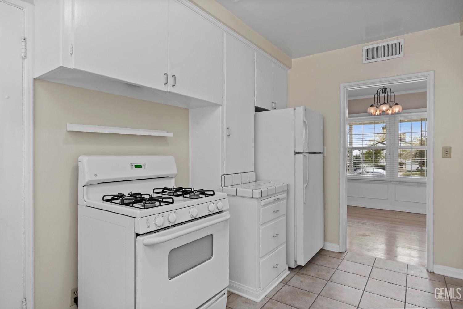 Undisclosed Address Bakersfield, CA 93308 - Photo 9 of 36 a kitchen with white cabinets and refrigerator