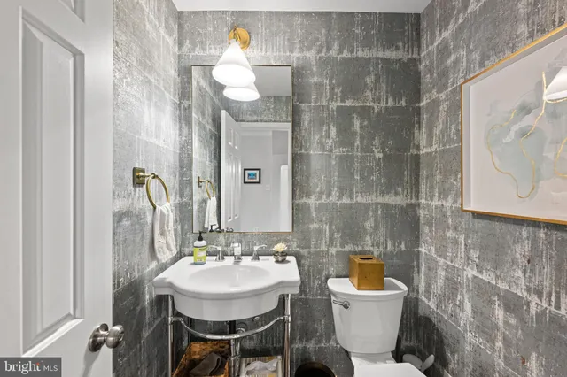 a bathroom with a sink a toilet and mirror