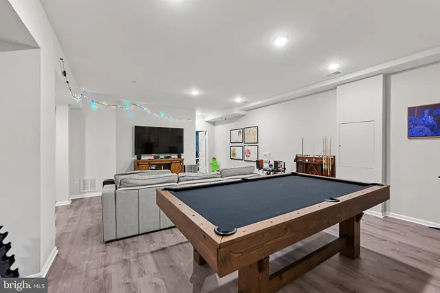 a room with furniture pool table and flat screen tv