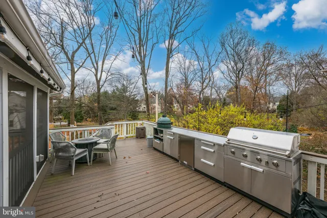 a balcony with wooden floor table and chairs