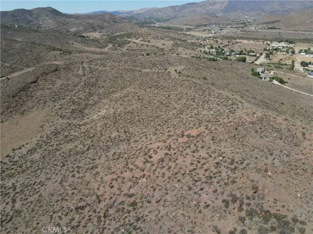 a view of a dry field with mountains in the background