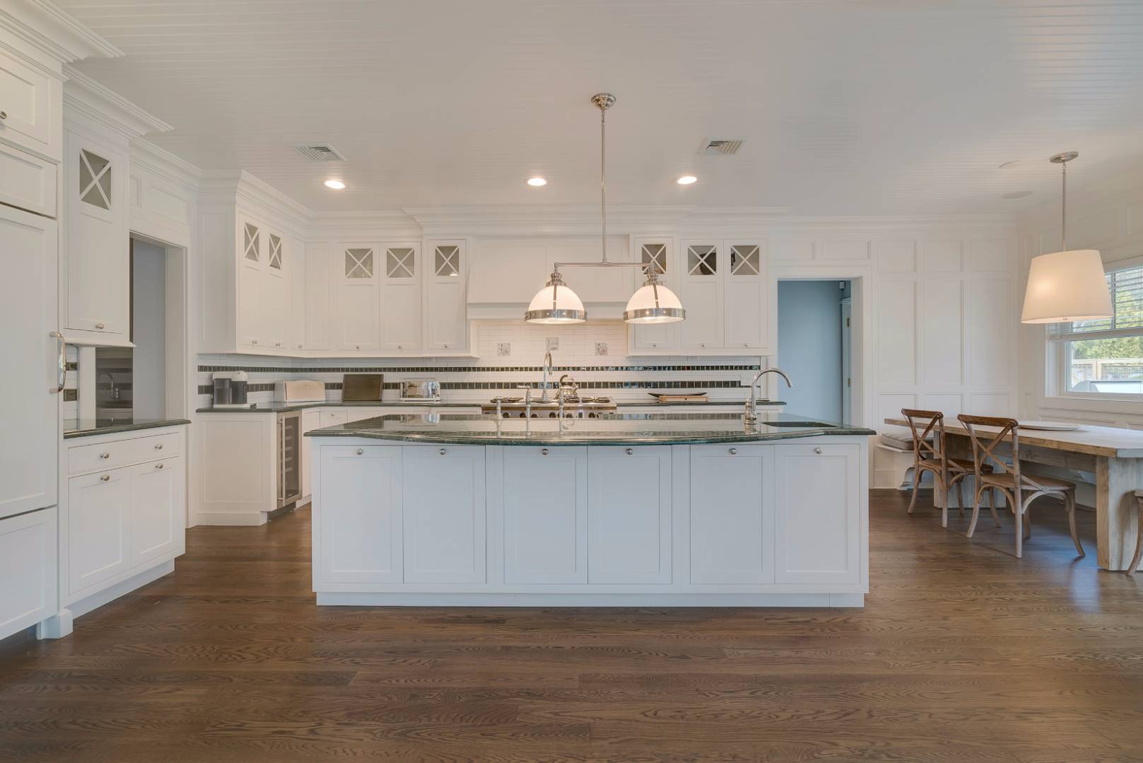 23 Deer Run Water Mill, NY 11976 - Photo 7 of 16 a large white kitchen with kitchen island a sink table and chairs