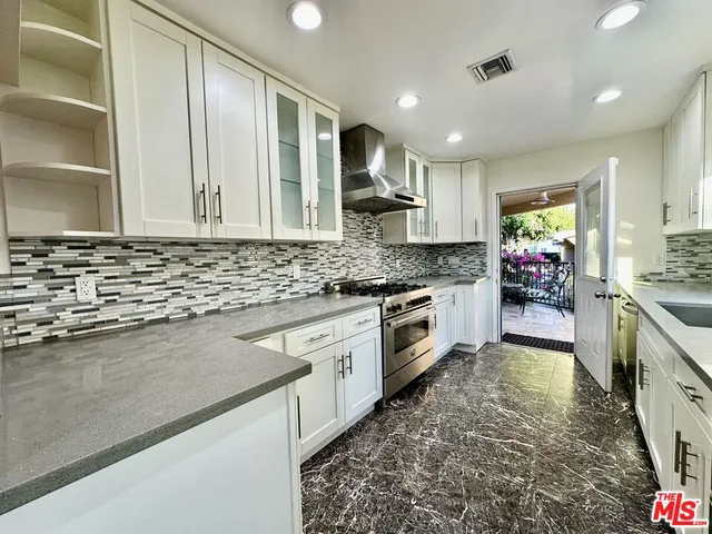 a kitchen with stainless steel appliances kitchen island granite countertop a stove a sink and a granite counter tops