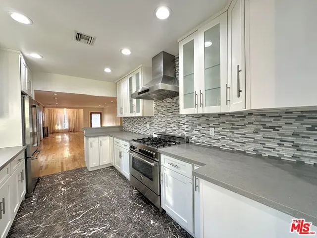 a kitchen with stainless steel appliances granite countertop a stove a sink and a refrigerator