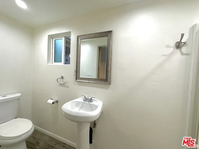 a bathroom with a toilet sink and mirror