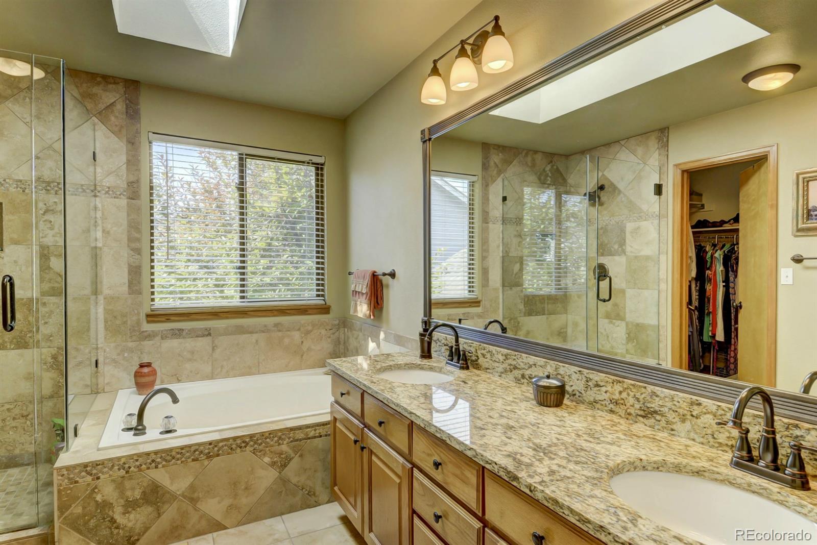 9932 South Spring Hill Place Highlands Ranch, CO 80129 - Photo 16 of 31 a bathroom with a granite countertop tub sink and mirror