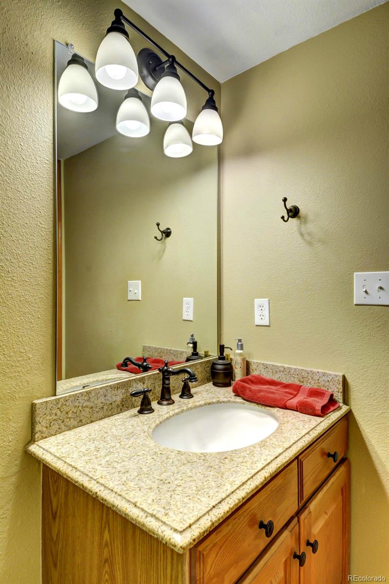 9932 South Spring Hill Place Highlands Ranch, CO 80129 - Photo 23 of 31 a bathroom with a granite countertop sink and a mirror