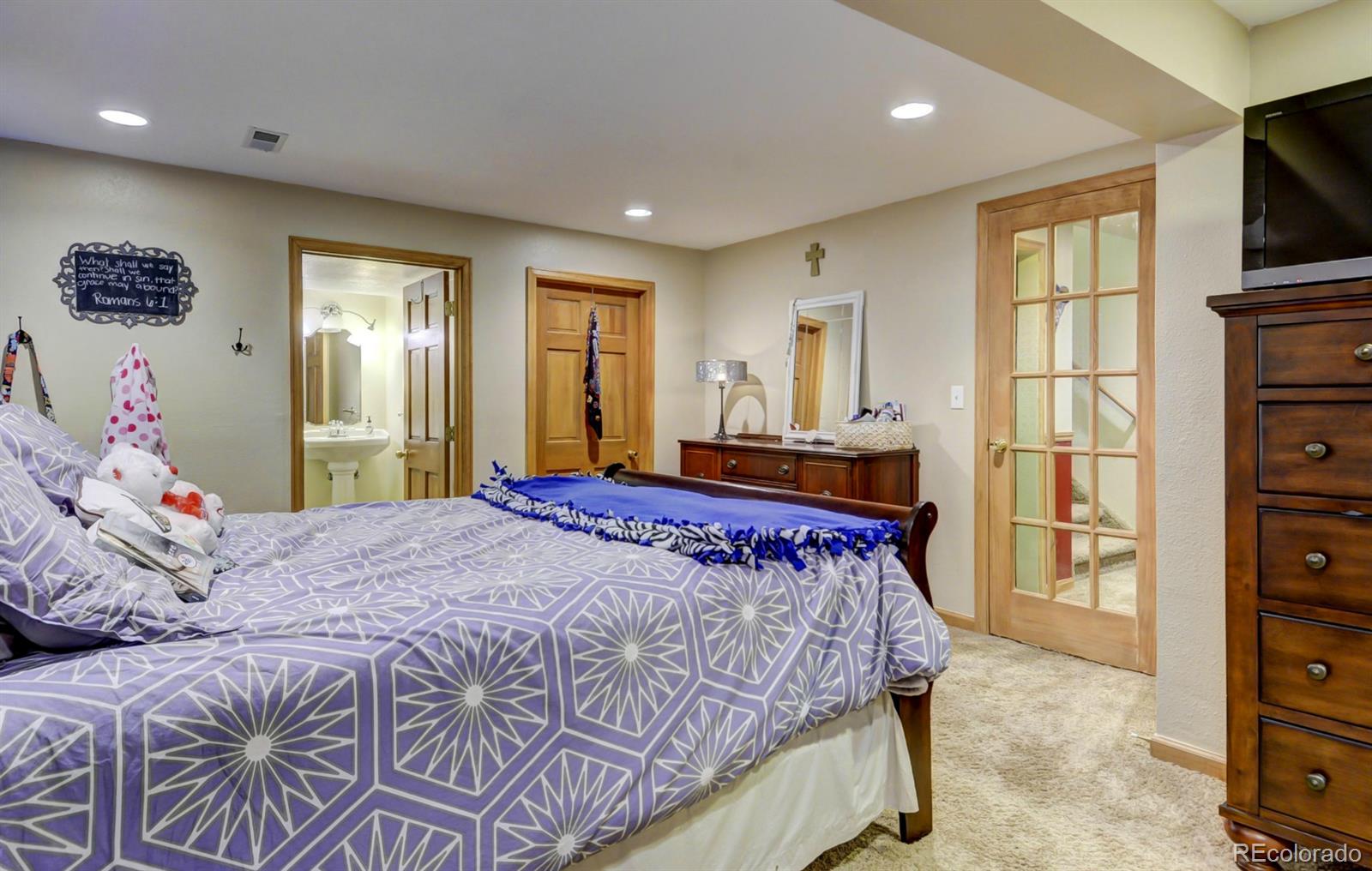 9932 South Spring Hill Place Highlands Ranch, CO 80129 - Photo 24 of 31 a bedroom with a bed and a flat screen tv