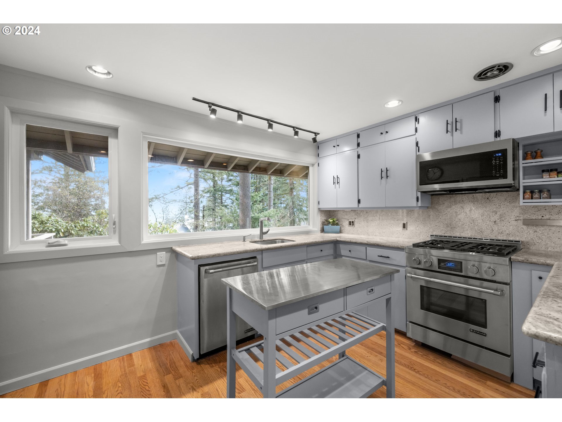 495 Northwest Greenleaf Road Portland, OR 97229 - Photo 15 of 45 a kitchen with kitchen island a stove a sink and a microwave