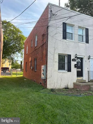 a view of backyard with barbeque grill potted plants and large tree
