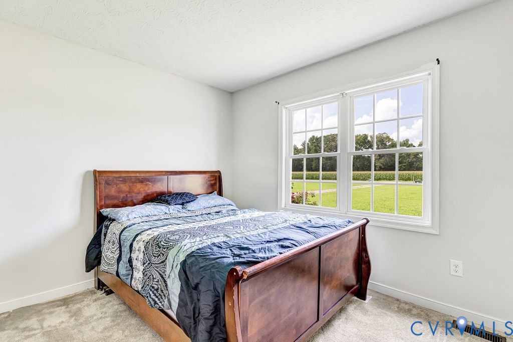 1018 Eubanks Road Dunnsville, VA 22454 - Photo 15 of 26 a bedroom with a bed and a large window