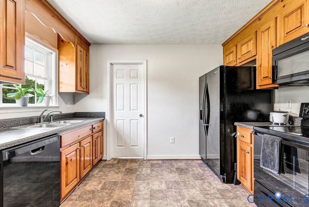 1018 Eubanks Road Dunnsville, VA 22454 - Photo 7 of 26 a kitchen with stainless steel appliances granite countertop a stove a sink and a refrigerator