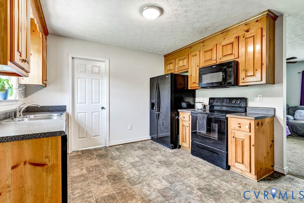 1018 Eubanks Road Dunnsville, VA 22454 - Photo 8 of 26 a kitchen with stainless steel appliances granite countertop a refrigerator stove and sink