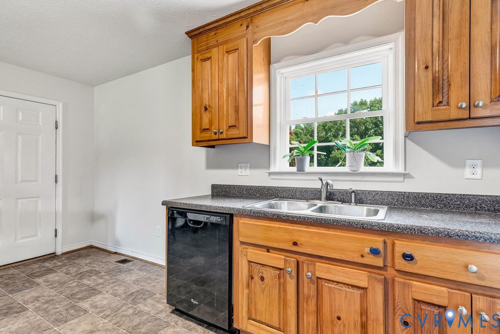 1018 Eubanks Road Dunnsville, VA 22454 - Photo 9 of 26 a kitchen with stainless steel appliances granite countertop a sink and a window