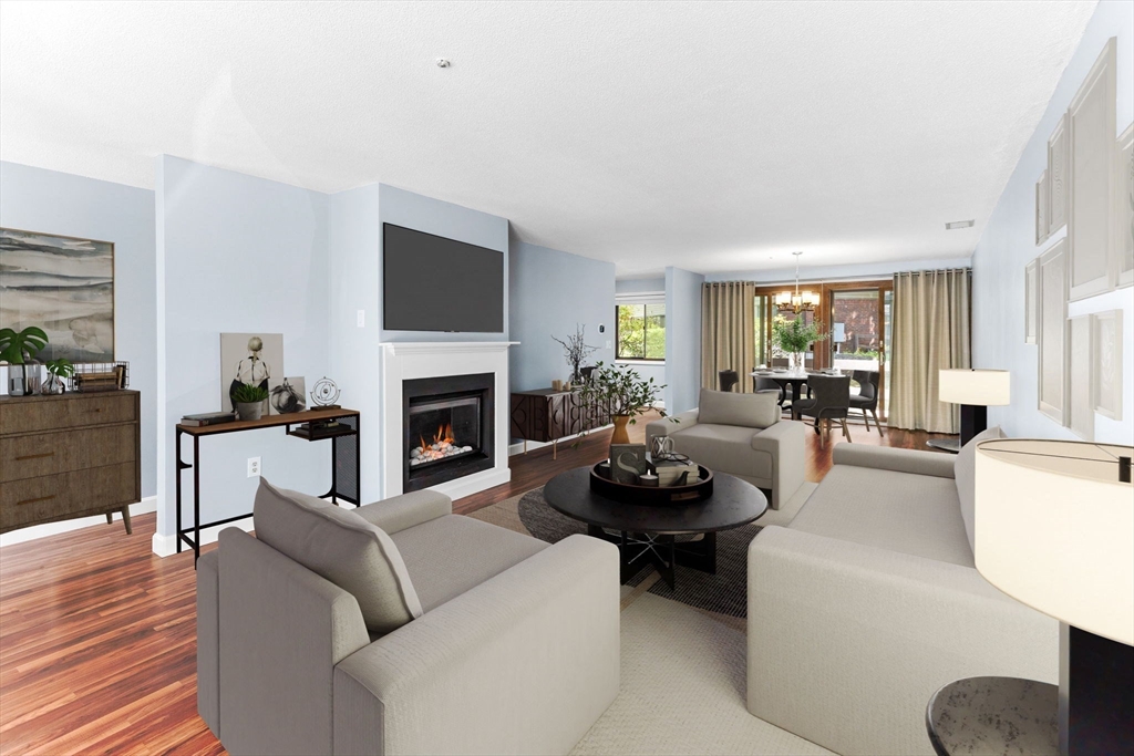 511 Tumbling Hawk, Unit 511 Acton, MA 01718 - Photo 12 of 42 a living room with furniture a fireplace a flat screen tv and a large window