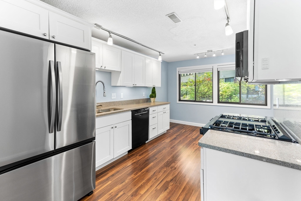 511 Tumbling Hawk, Unit 511 Acton, MA 01718 - Photo 14 of 42 a kitchen with stainless steel appliances a refrigerator sink and stove