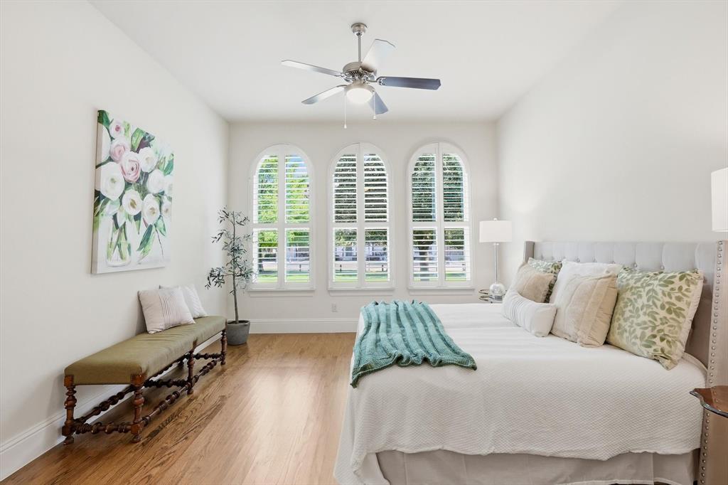 516 Sandy Lane Flower Mound, TX 75022 - Photo 17 of 38 Room featuring three arched windows with plantation shutters, wood-finish flooring, a vaulted ceiling, and a ceiling fan with integrated lighting