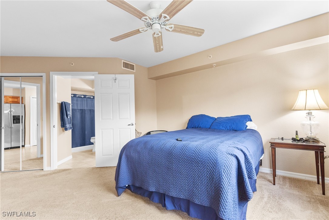 4965 Sandra Bay Drive, Unit 103 Naples, FL 34109 - Photo 13 of 30 a bed room with a bed and a lamp