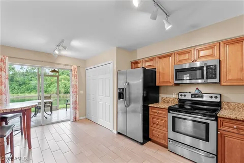 a kitchen with stainless steel appliances granite countertop a refrigerator microwave and stove top oven