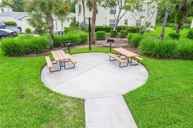 a bench sitting in the middle of a park with large trees