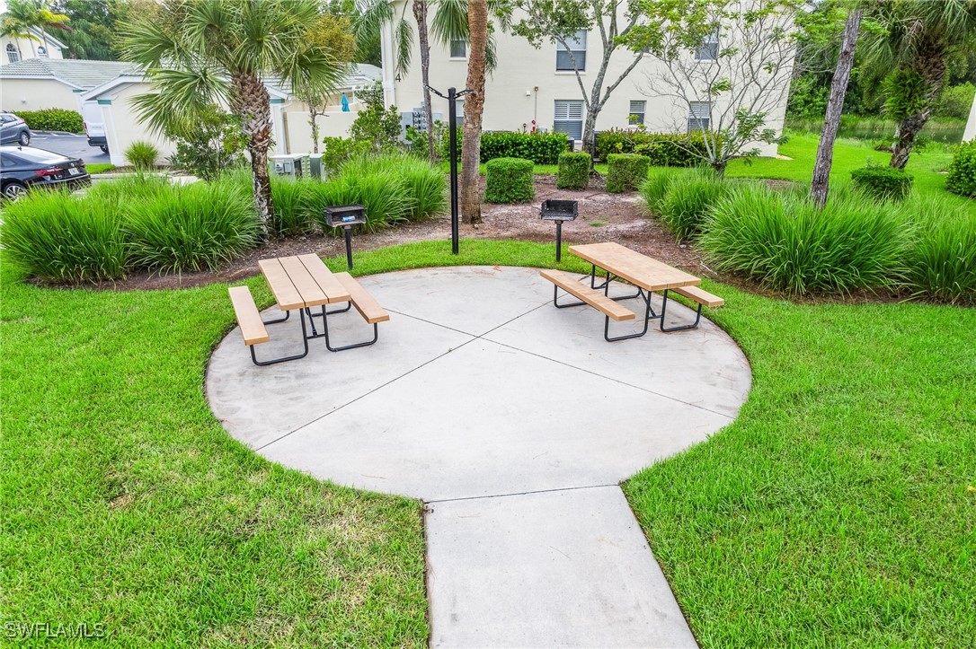 4965 Sandra Bay Drive, Unit 103 Naples, FL 34109 - Photo 29 of 30 a bench sitting in the middle of a park with large trees