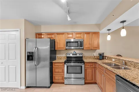a kitchen with stainless steel appliances granite countertop a refrigerator stove and sink