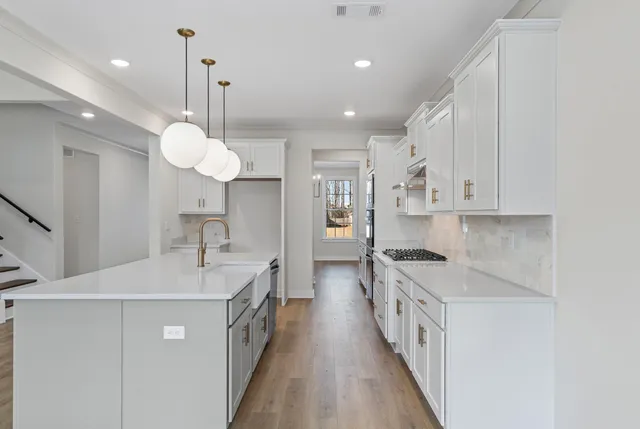 a kitchen with kitchen island a sink and stove