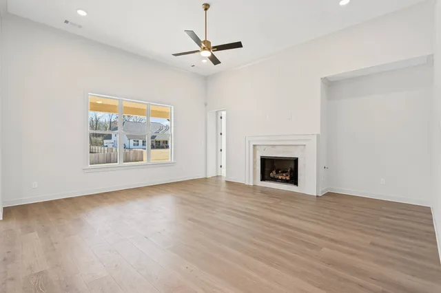a view of an empty room with a fireplace and a window