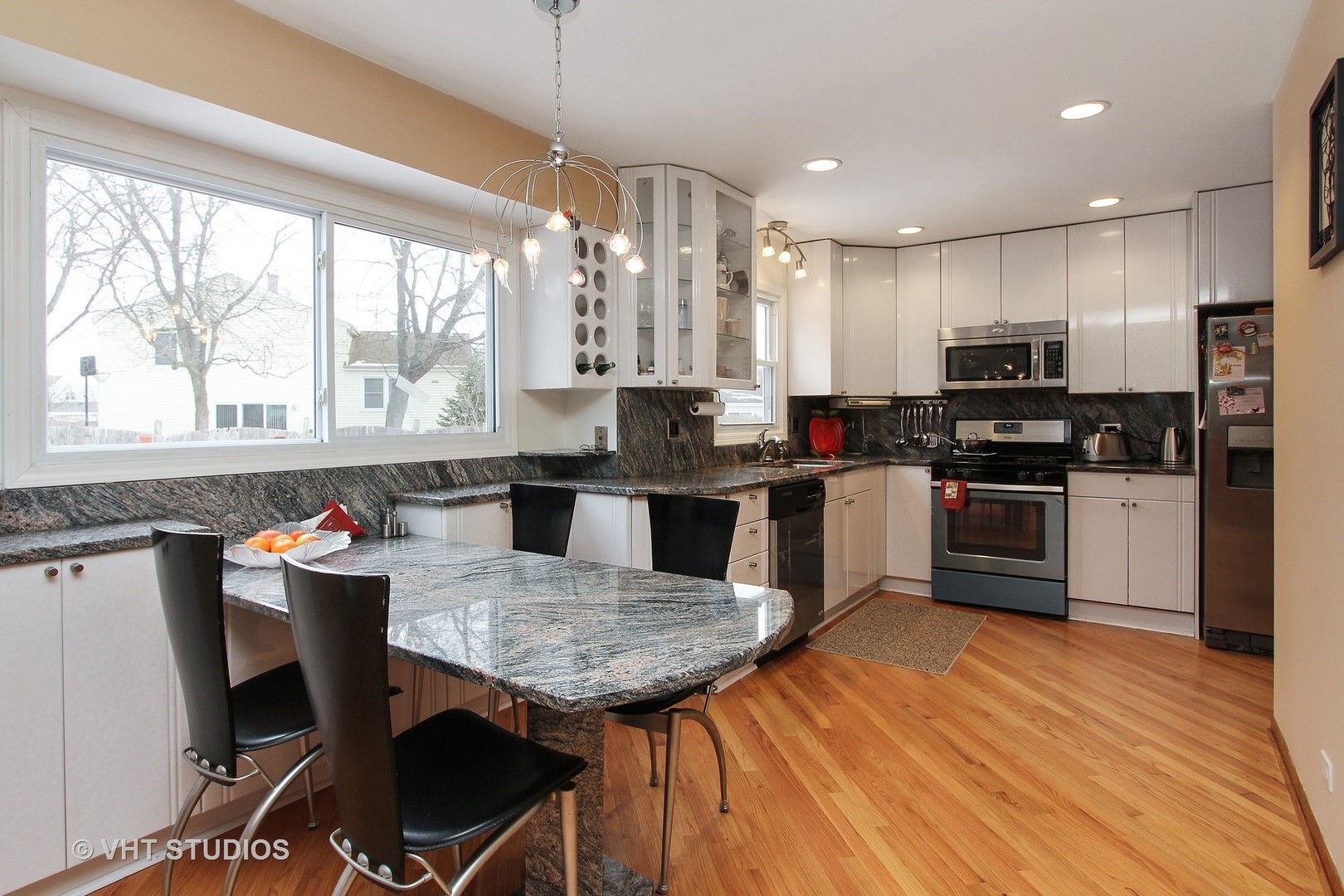 1104 Devonshire Road Buffalo Grove, IL 60089 - Photo 3 of 10 a kitchen with stainless steel appliances granite countertop a stove top oven a sink dishwasher a dining table and chairs with wooden floor