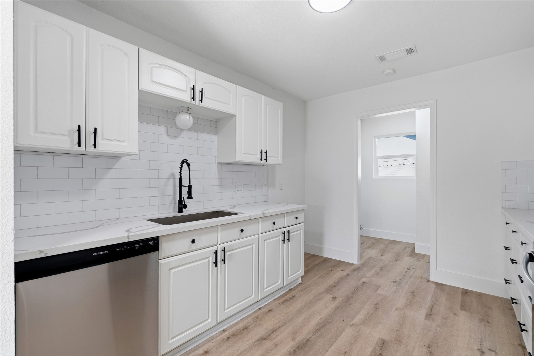 9809 Wren Court Conroe, TX 77385 - Photo 11 of 22 a kitchen with a sink cabinets and wooden floor